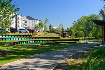 A park with benches and buildings in the background